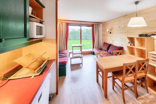 une cuisine et un salon avec une table et des chaises dans l'établissement Résidence L'Alpaga - maeva Home - Studio 4 personnes - Confort MAE-2105, à La Salle Les Alpes