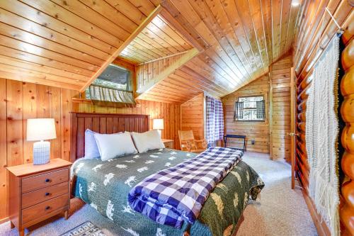 ein Schlafzimmer mit einem Bett in einer Holzhütte in der Unterkunft Saranac Lake Cabin with Deck Pets Welcome! in Saranac Lake