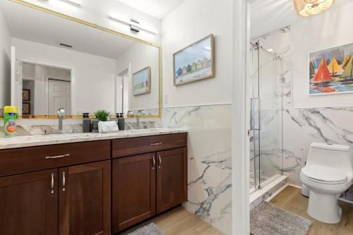 a bathroom with a sink and a toilet and a shower at Serenity Haven Luxe Pet Friendly 5BR With Pool in Clearwater