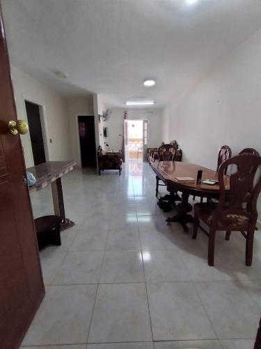 uma sala de estar com uma mesa de madeira e cadeiras em شقة 2 غرفة بتكييف em Marsa Matruh
