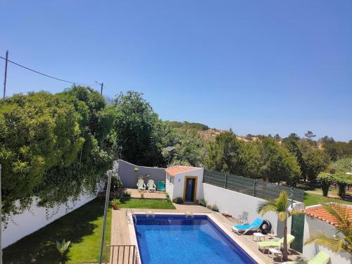 a villa with a swimming pool and a house at Vicentina Rooms by Casas do Alentejo in Almograve