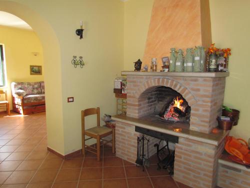 a living room with a brick fireplace with a fire at Tenuta Armida Relax & Pool in Liberi