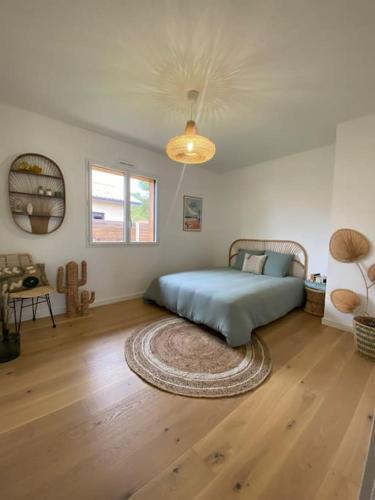 - une chambre avec un lit et un tapis sur du parquet dans l'établissement Magnifique Villa Lege Cap Ferret avec piscine, à Lège-Cap-Ferret