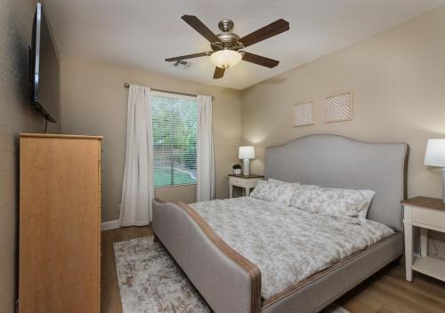 - une chambre avec un lit et un ventilateur de plafond dans l'établissement 5BR Lux Paradise Pool Spa Resort Backyard Bliss, à Chandler
