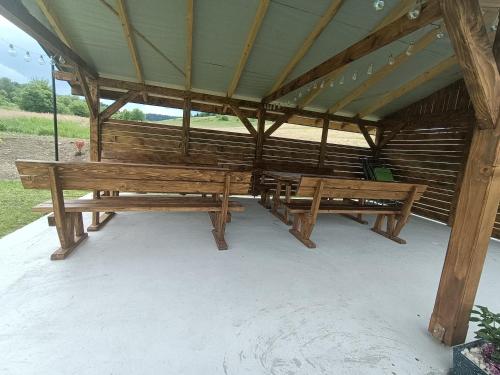 a group of benches sitting under a pavilion at Zielona Dolina Hoczew in Hoczew