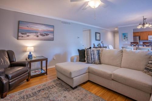 een woonkamer met een bank en een stoel bij Lovely 3 bedroom first floor condo on golf course in Sarasota