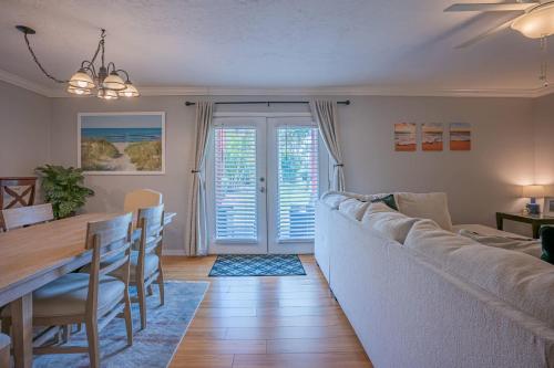 een woonkamer met een grote bank en een eettafel bij Lovely 3 bedroom first floor condo on golf course in Sarasota