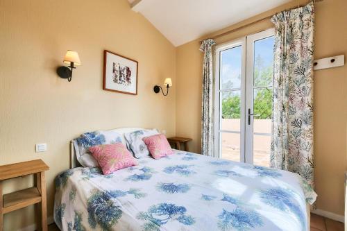 une chambre avec un lit et une grande fenêtre dans l'établissement Les Maisons aux Restanques du Golfe de St Tropez - maeva Home - Maison Duplex 4 Pièces avec terrasse vue végétation 8 personnes - Prestige MAE-2842, à Grimaud