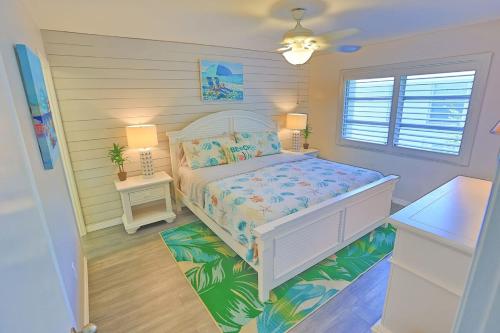 a bedroom with a white bed and a window at Updated Condo with Pool, Walk to Crescent Beach & Restaurants! in Sarasota