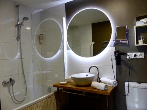 a bathroom with a sink and a shower and a mirror at Appart'hôtel - Seclin-Appartements in Seclin