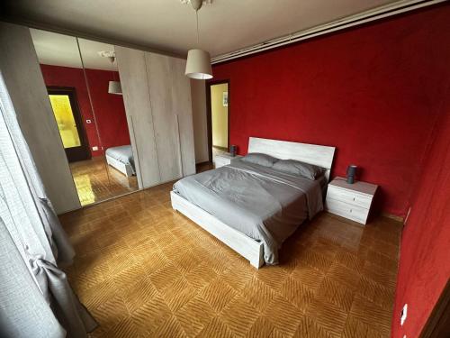 una camera con letto e parete rossa di La Villa a Pessinetto