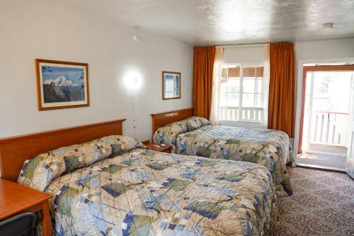 a hotel room with two beds and a window at Swiss Holiday Lodge in Mount Shasta