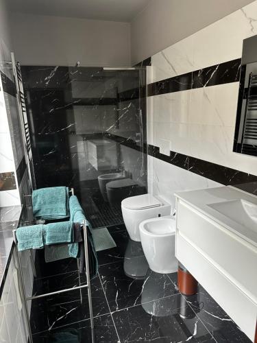 un bagno bianco e nero con due servizi igienici e un lavandino di La Villa a Pessinetto