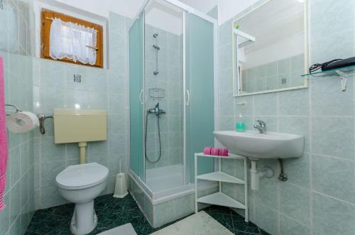y baño con ducha, aseo y lavamanos. en Apartments Jakov, en Jelsa
