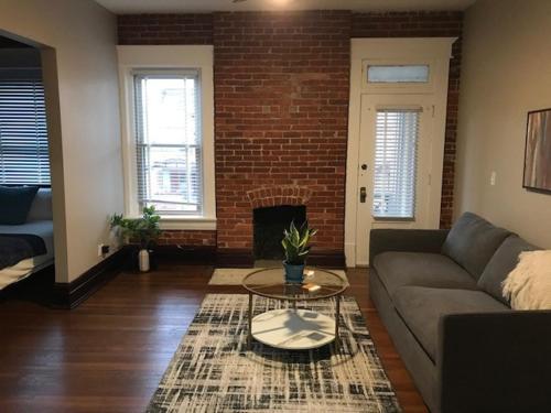 a living room with a couch and a fireplace at Big Brick 2 Bedroom apartment in Victorian Village in Columbus