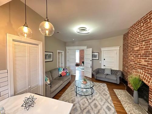 a living room with a couch and a brick wall at Big Brick 2 Bedroom apartment in Victorian Village in Columbus