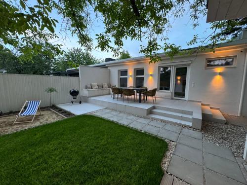 a patio with a table and chairs in a yard at Bánhiday H31 Beach house in Balatonakarattya