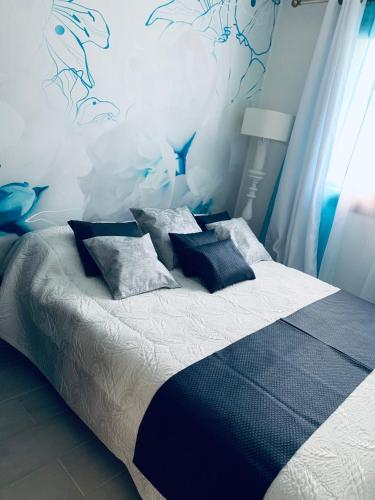 - une chambre bleue avec un lit et des oreillers dans l'établissement Villa NYVIONI, proche de la mer, avec piscine et SPA, au Grau-dʼAgde