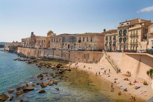 a group of people on a beach near the water at Palazzo Spagna in Siracusa