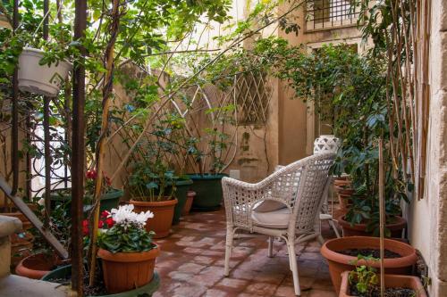 a patio area with a patio table, chairs, and plants at Palazzo Spagna in Syracuse