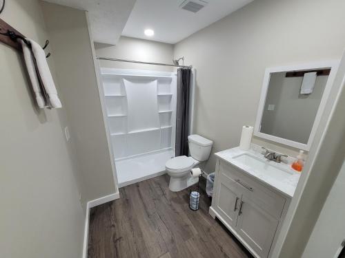 a white bathroom with a toilet and a sink at Barefoot Hills in Dahlonega