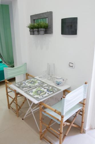 a dining room table with two chairs and a table at Palazzo Spagna in Siracusa