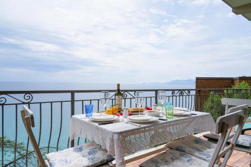 a table with food and a bottle of wine on a balcony at Villa Infinito Blu in Borgio Verezzi