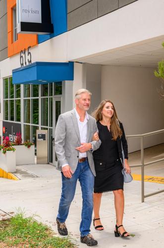 a man and a woman standing in front of a building at Revisn in Raleigh