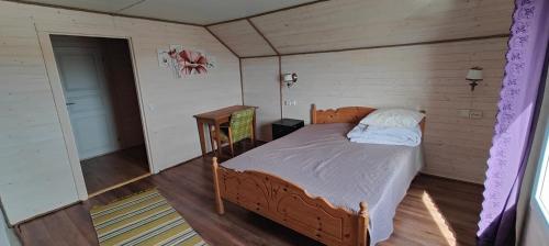 um quarto com uma cama num quarto com pisos em madeira em Barents sea window em Ytre Kiberg