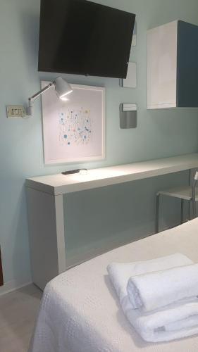 a bedroom with a bed and a desk with a lamp at Hotel Rosati in Rimini