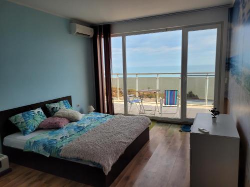 a bedroom with a bed with a view of the ocean at SKY INFINITY in Balchik
