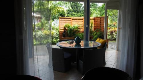 a dining room with a table and a large window at Habitation Cantamerle in Capesterre-Belle-Eau