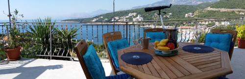 a wooden table with a bowl of fruit on a balcony at Apartment Carpe Diem with the best sea view, Utjeha Montenegro Mediterranean Eu in Masline