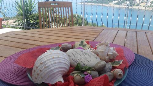 a plate with a shell and rocks on a table at Apartment Carpe Diem with the best sea view, Utjeha Montenegro Mediterranean Eu in Masline