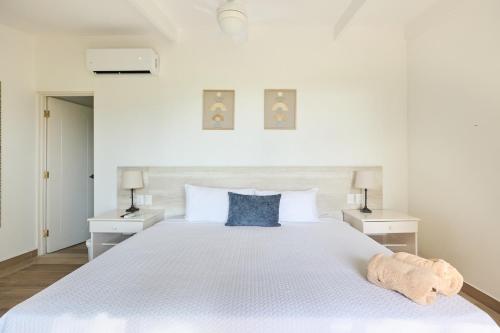 タマリンドにあるHotel Perla de la Playaの白いベッドルーム(青い枕の大きな白いベッド付)