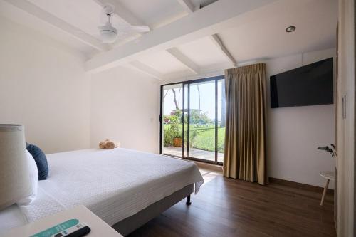 1 dormitorio con cama grande y ventana grande en Hotel Perla de la Playa en Tamarindo