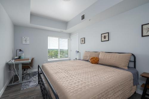 a bedroom with a bed and a desk and a window at 2 Bedroom 2 Bath Brand New Apartment Next To Mayo! in Rochester