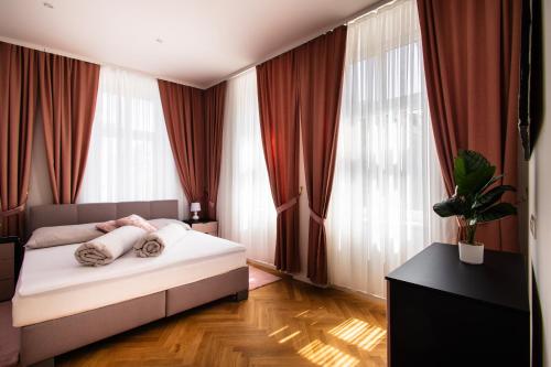 1 dormitorio con 1 cama frente a las ventanas en Royal Residences Vienna, en Viena