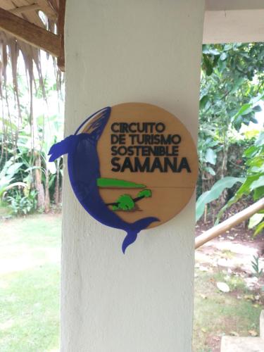 a sign on the side of a building with a fish on it at Quédate Aquí in Las Galeras