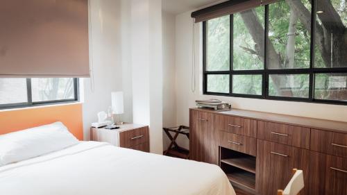a bedroom with a bed and a large window at Suites del Valle in Mexico City