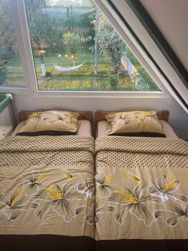 a bed in a room with a large window at Vikendica Živković in Lazarevac