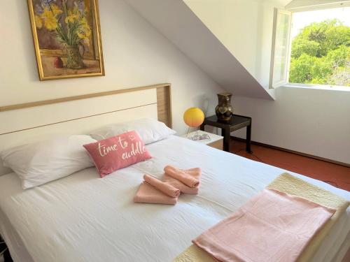 a bedroom with a bed with two pink towels on it at Bonaca apartment and rooms in Dubrovnik