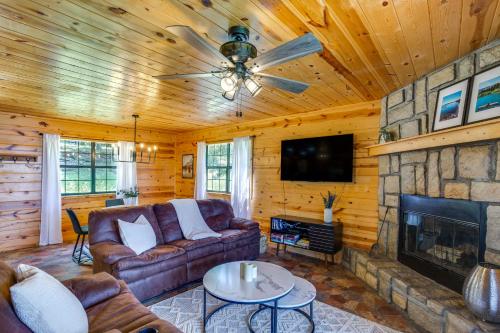 a living room with a couch and a fireplace at Cabin on Lake Raymond Gary with Dock, Grill and Views! in Fort Towson