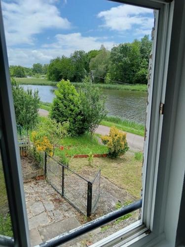 a window with a view of a river and trees at Logis du Nivernais in Saint-Léger-des-Vignes