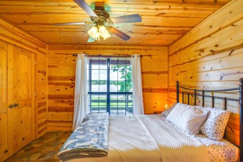 a bedroom with a bed and a ceiling fan at Cabin on Lake Raymond Gary with Dock, Grill and Views! in Fort Towson