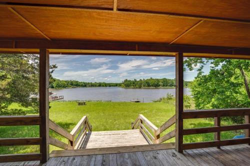 a screened in porch with a view of a lake at Cabin on Lake Raymond Gary with Dock, Grill and Views! in Fort Towson