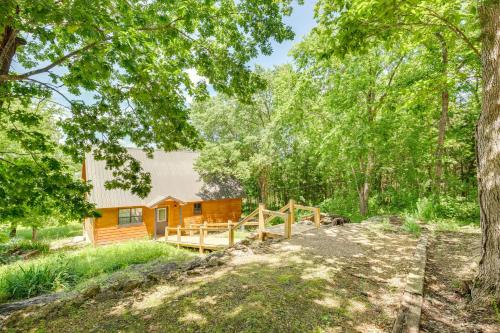 a cabin in the woods with a deck and trees at Cabin on Lake Raymond Gary with Dock, Grill and Views! in Fort Towson