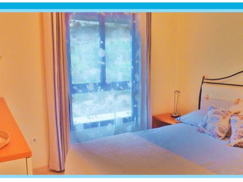 een slaapkamer met een bed en een raam bij Apartamento BURRIANA NERJA Nsf50 in Nerja