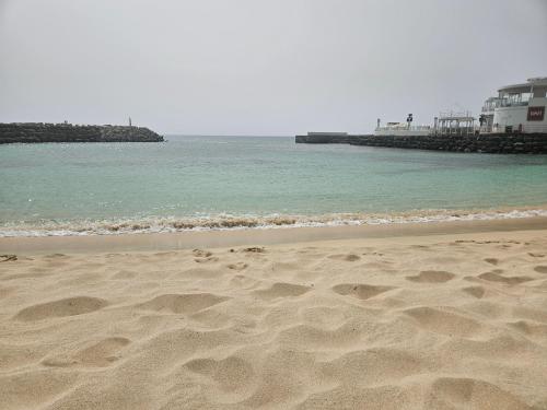 a beach with footprints in the sand and the ocean at Private Apartment At Tortuga Beach Resort and Spa in Santa Maria