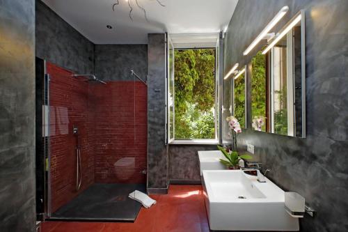 La salle de bains est pourvue de 2 lavabos et d'une douche. dans l'établissement AMM Luxury Rooms, à Rome